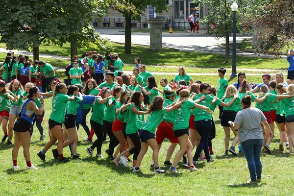 Students holding each other's shoulders in a line during Orientation week