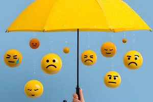 yellow umbrella over various emoji emotion balls