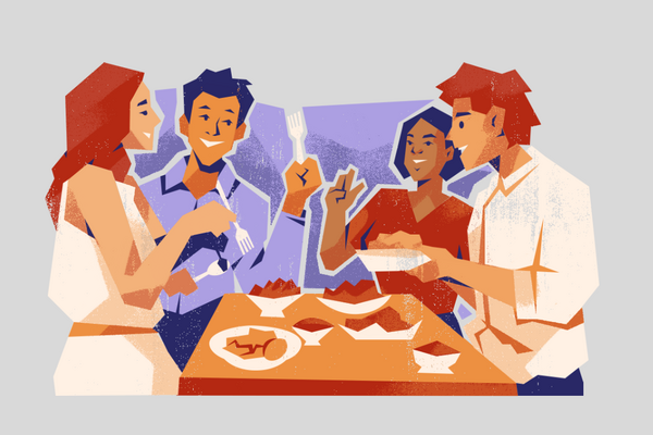 four people around a table eating