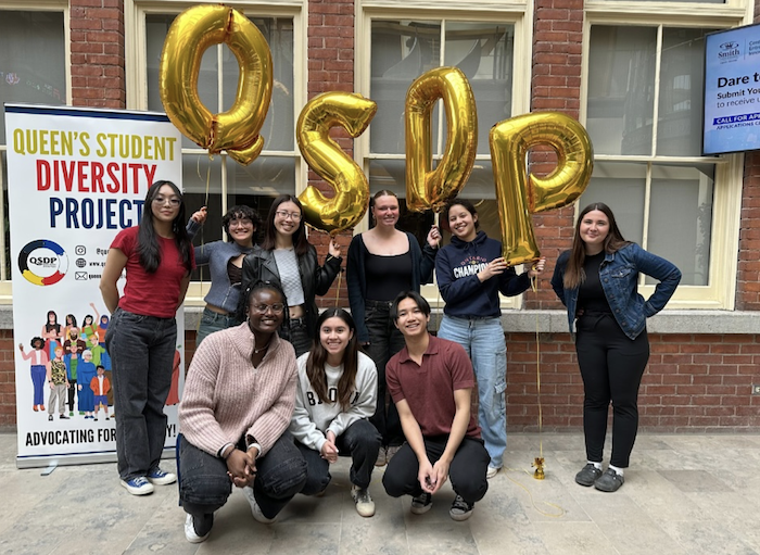 Students gathered in front of QSDP banner and balloons