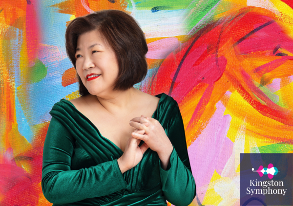 Angela Cheng poses in front of a multicoloured painted background