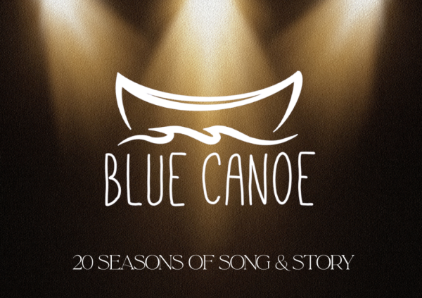 The blue canoe logo dramatically lit by spotlights
