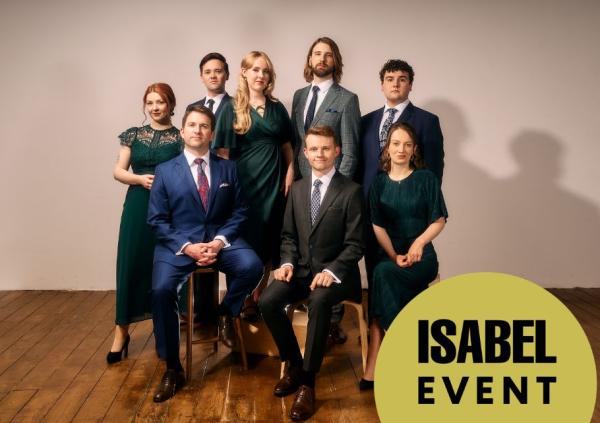 The 8 singers pose for the camera, all dressed in beautiful jewel-toned outfits