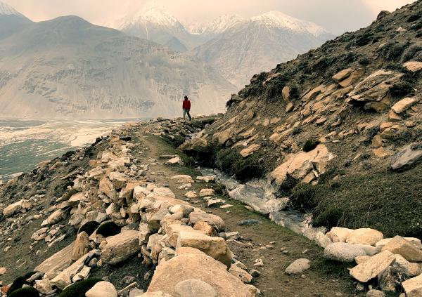 A lone figure stands on a dramatic cliffside