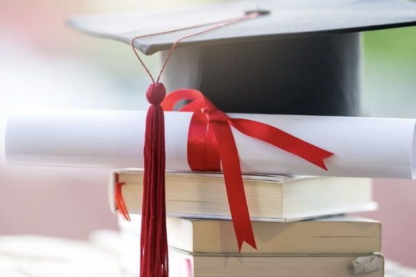 Grad cap and diploma on books