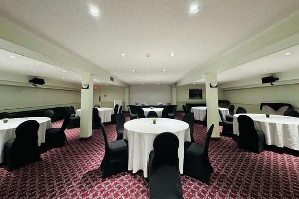 Downstairs conference room set with round tables and chairs