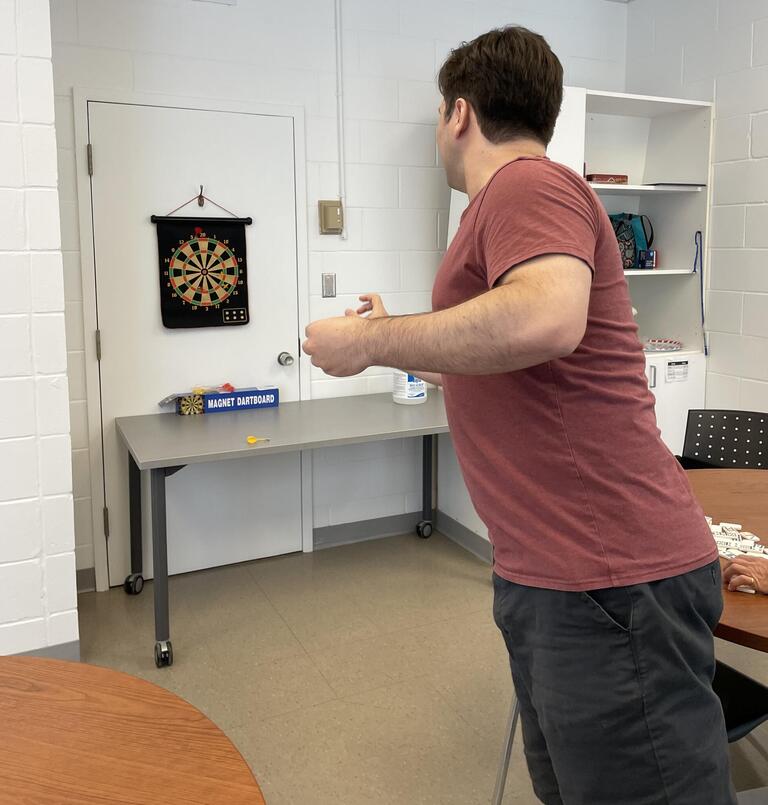 Man throwing dart at dart board