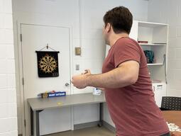 Man throwing dart at dart board