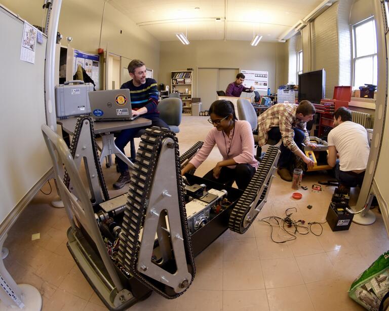 People working in a laboratory on robots