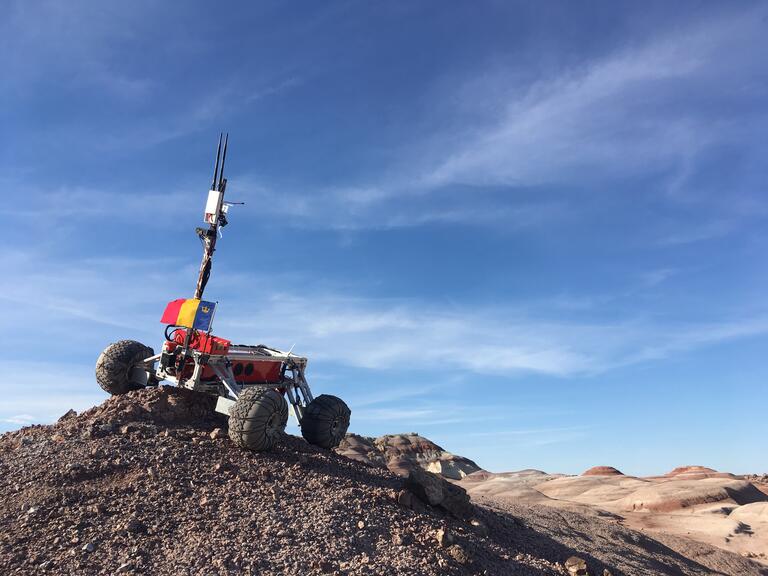 A mechanical rover on a mound of dirt