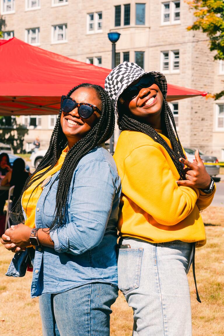 two people dressed in yellow shirts posing together outside