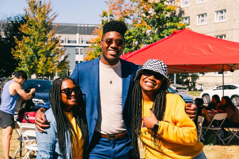 three people posing next to each other in the sun