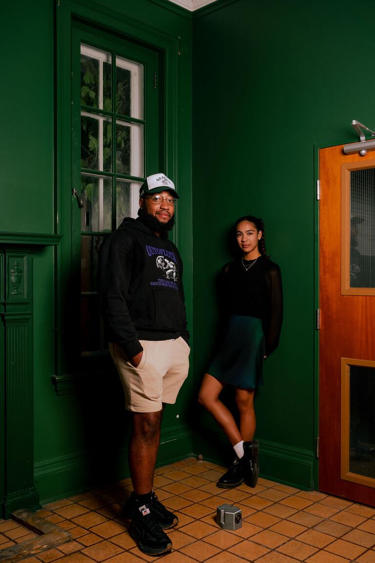 two people posing at the corner of a green room